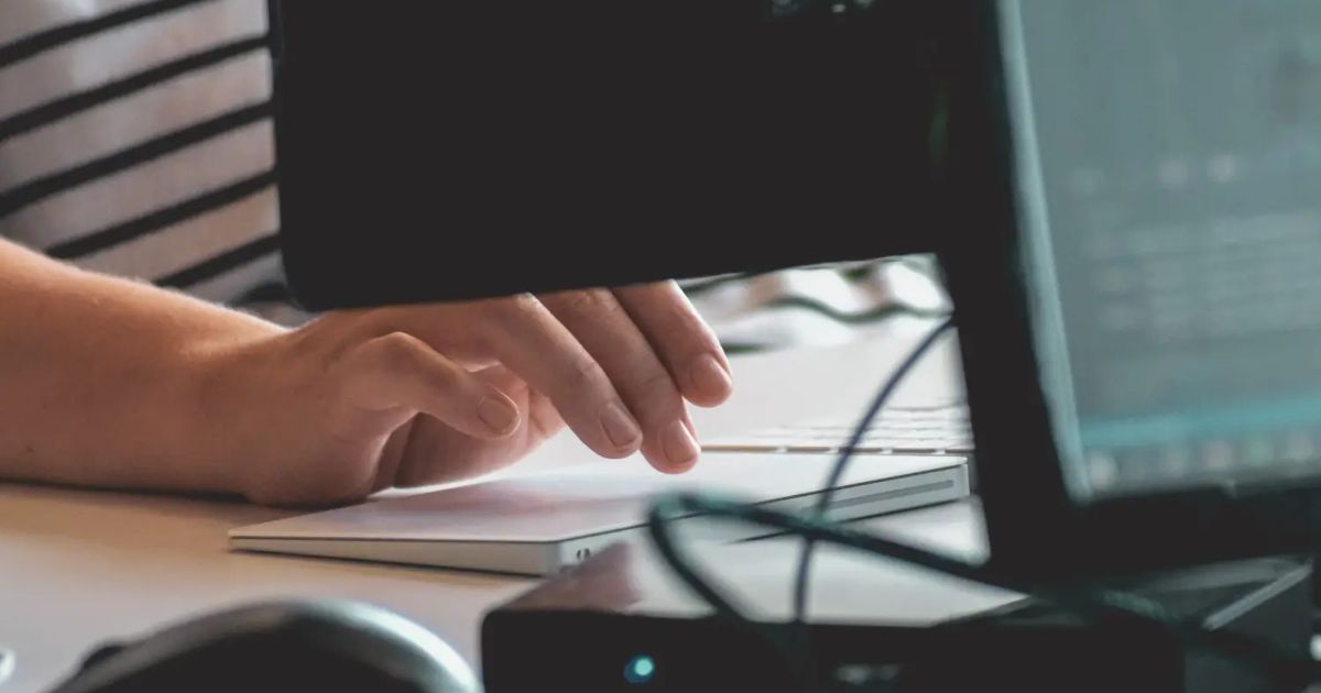 Hand poised over a laptop keyboard